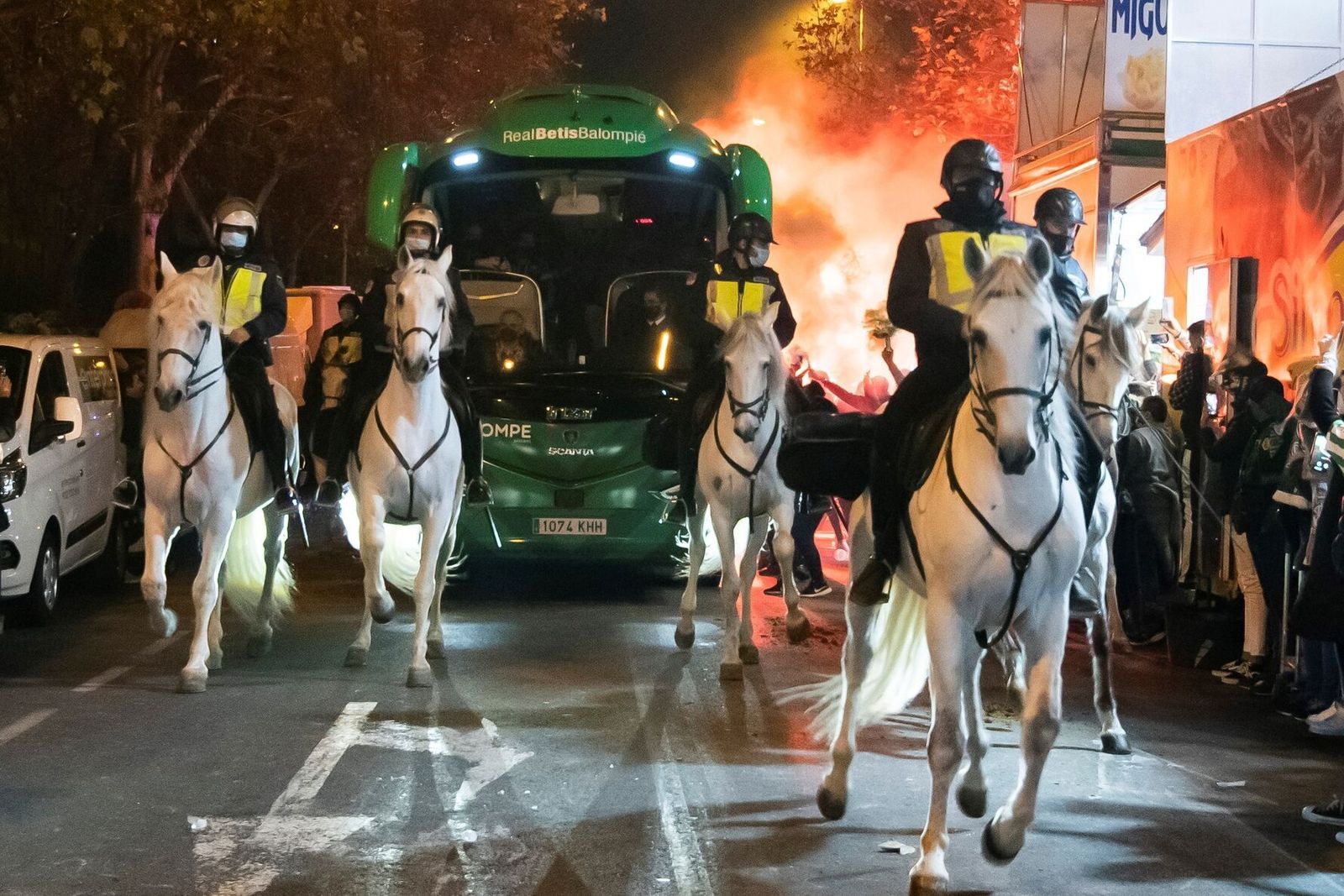 Miembros de la Policía Nacional, a caballo, vigilan en primera línea el autobús del Betis a su llegada al Benito Villamarín en el último derbi copero.