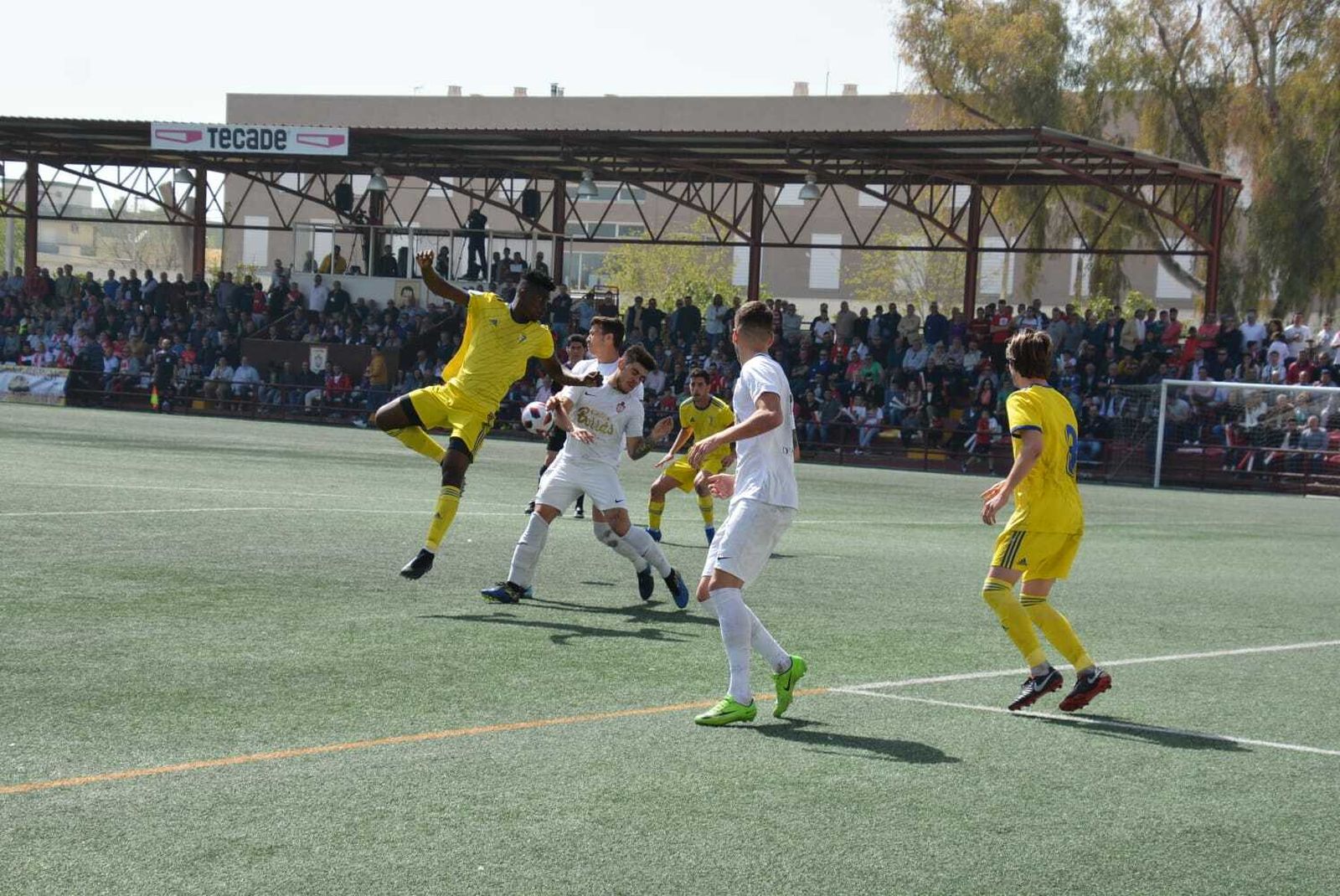 Saturday pugna por el balón junto a dos jugadores del Utrera.