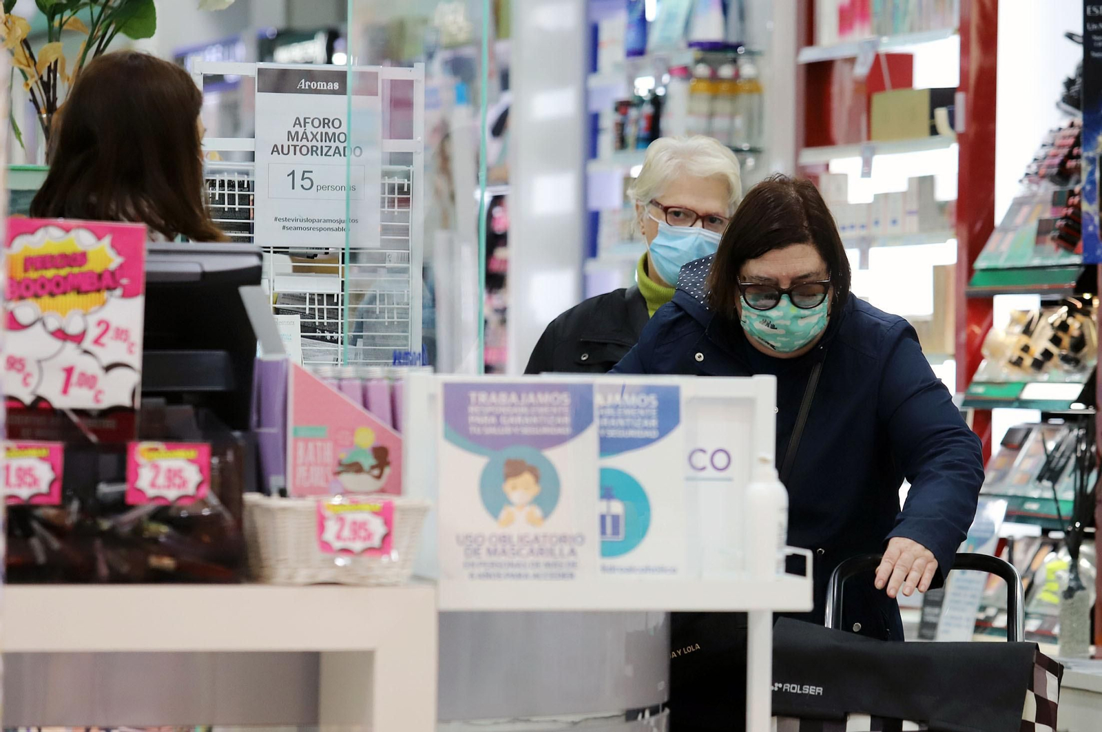 Varias personas con mascarillas en un comercio de la capital onubense.
