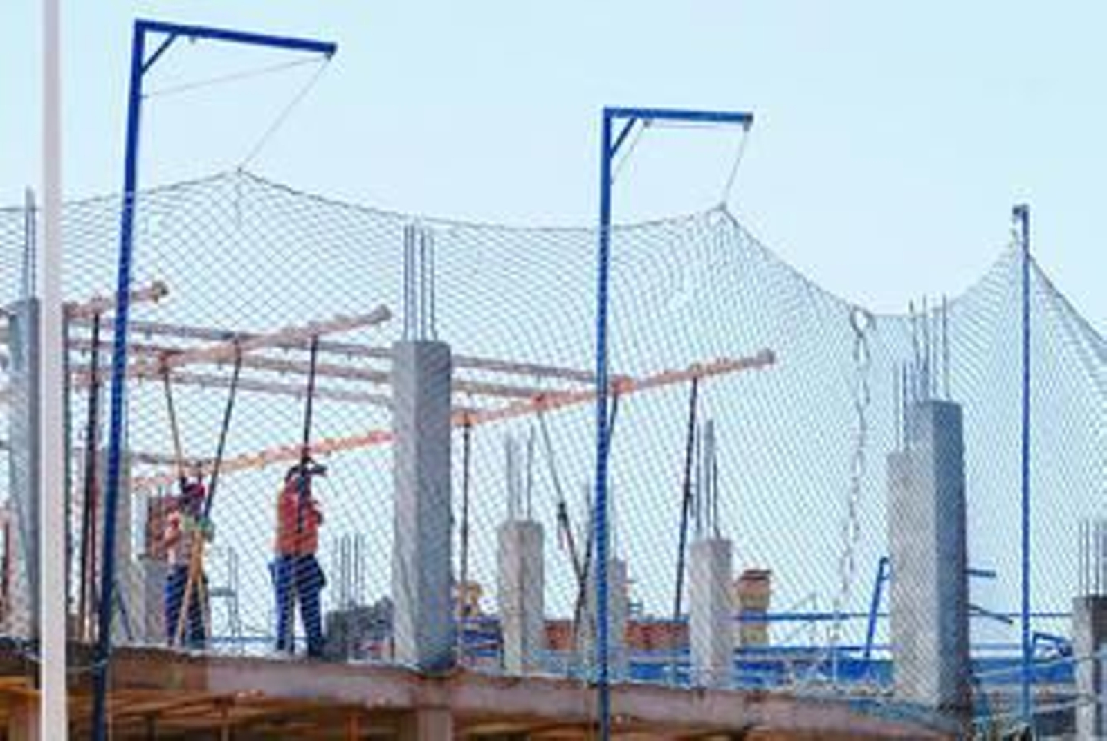 Dos albañiles trabajan en la construcción de un bloque de viviendas.