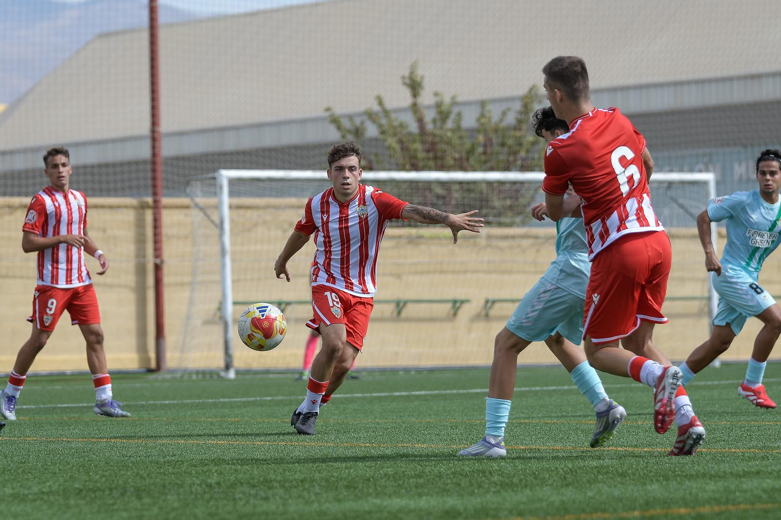 Un par de jugadores del conjunto rojiblanco disputan un balón con un rival durante un choque disputado en el Francisco Pomedio.