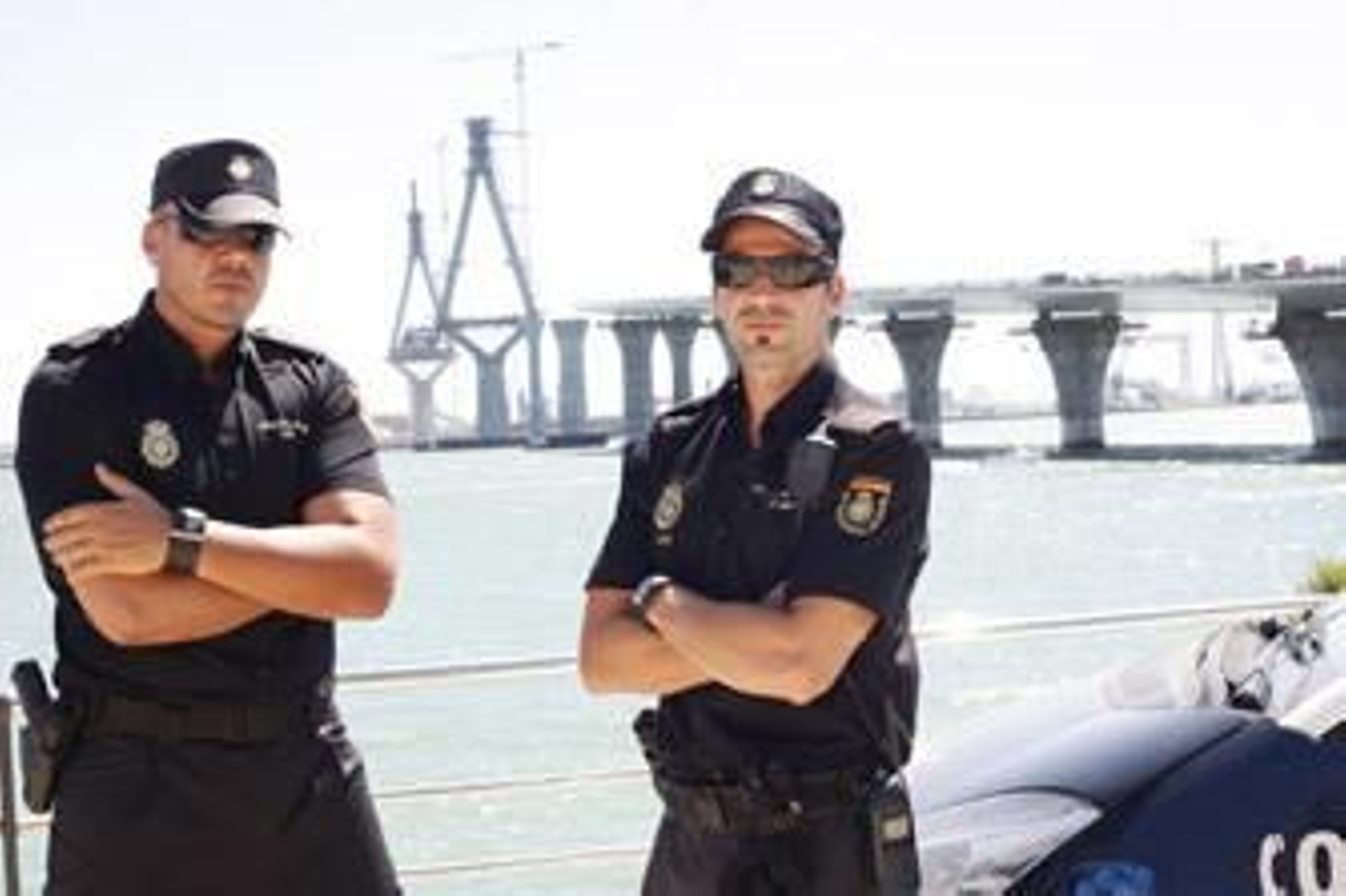 Los dos agentes de policía que ayudaron al hombre, ayer ante el nuevo puente. /Joaquín Pino