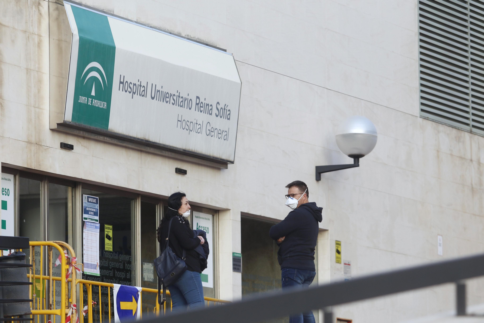 Dos personas en una de las entradas al Hospital Reina Sofía.