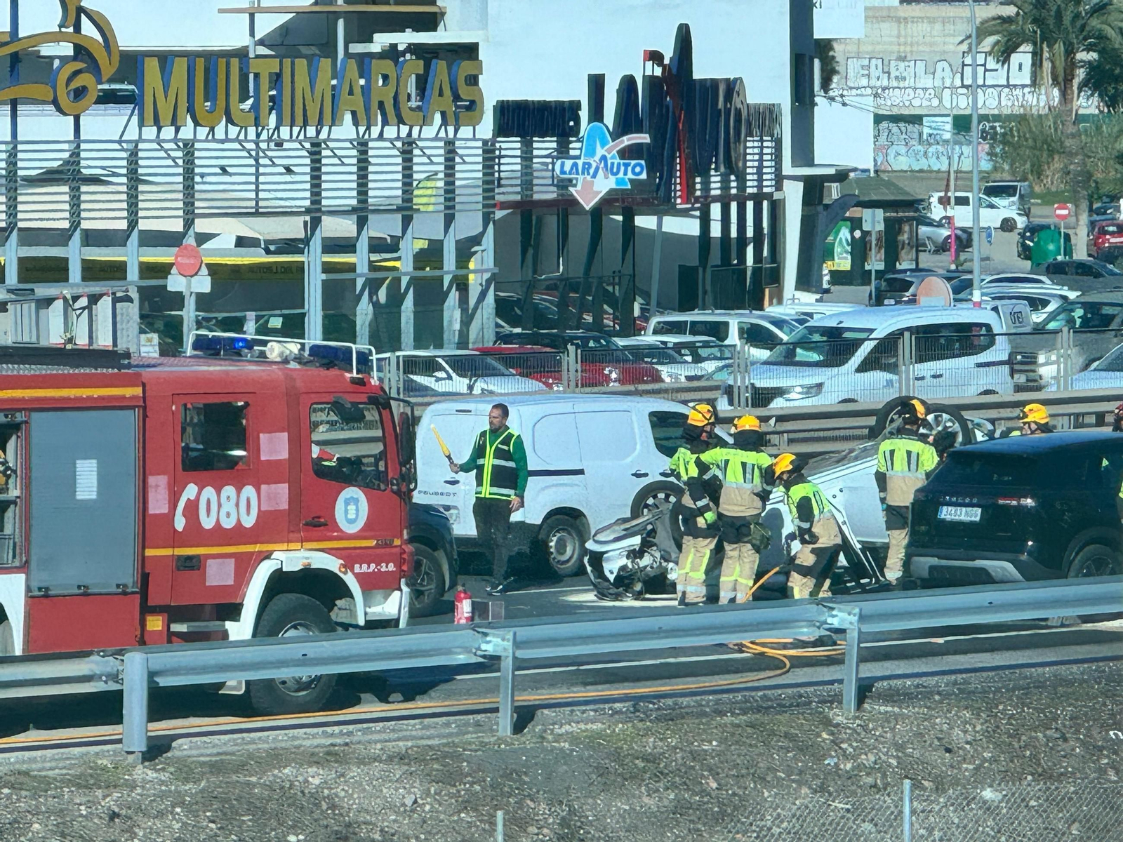 Bomberos actúan en el lugar en el que ha volcado el vehículo en la MA20