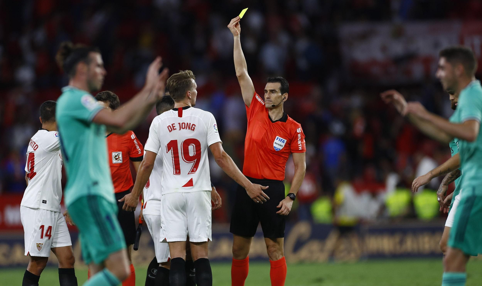 Martínez Munuera muestra a De Jong una tarjeta por protestar tras pitar el final del partido.