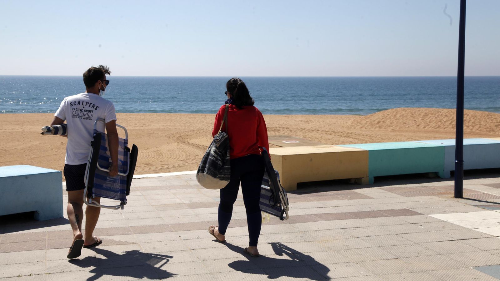 Dos bañistas acceden a una de las playas del litoral occidental onubense, este miércoles