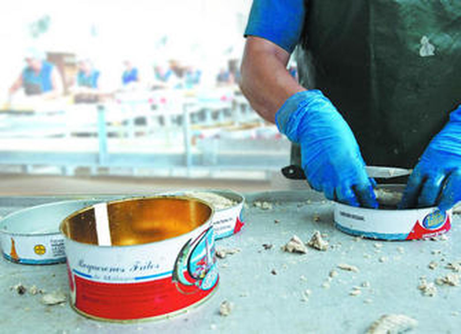 Una estibadora introduce pescado cocido en una lata de La Tarifeña.