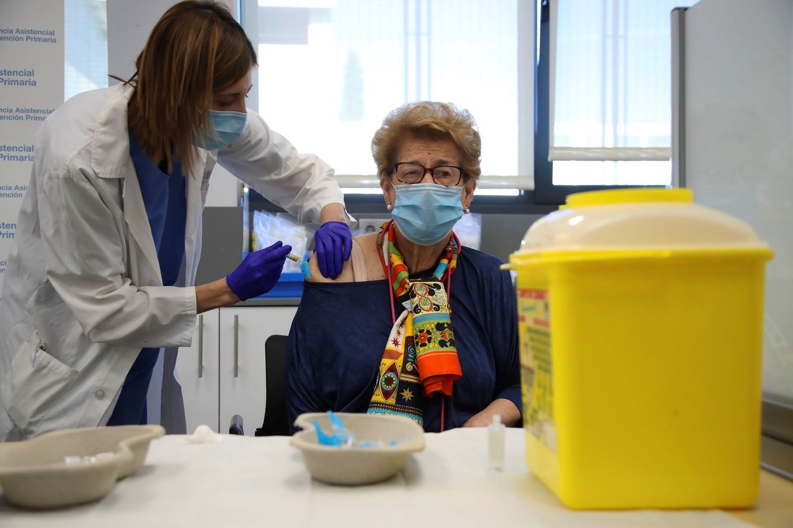 Una enfermera vacuna a una mujer contra la gripe.
