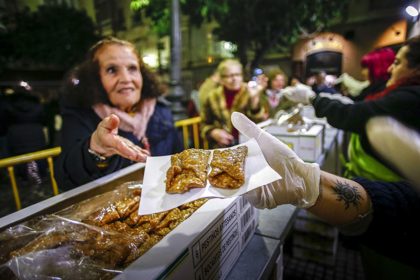 Reparto de pestiños en la plaza de San Francisco.