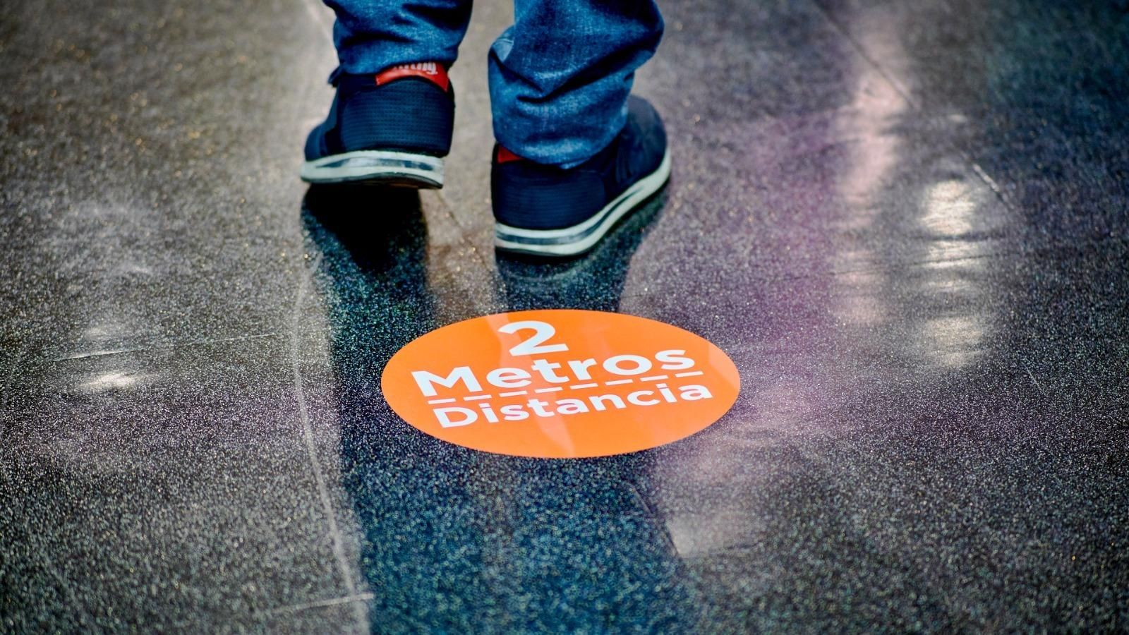 Información en el suelo de un establecimiento para respetar la distancia de seguridad.