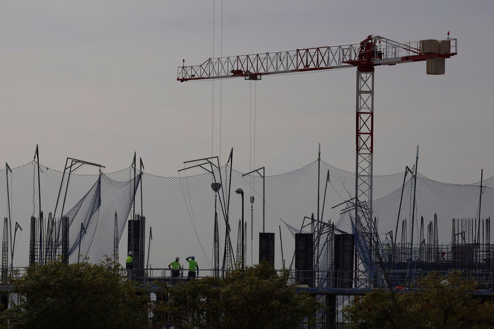 Grúa y obreros en una promoción de VPO de Málaga.