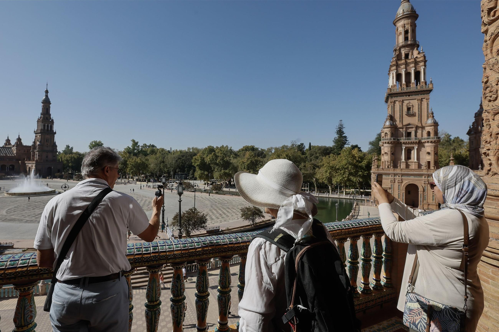 Unos turistas toman fotos en la plaza de España de Sevilla. Unos turistas toman fotos en la plaza de España de Sevilla.