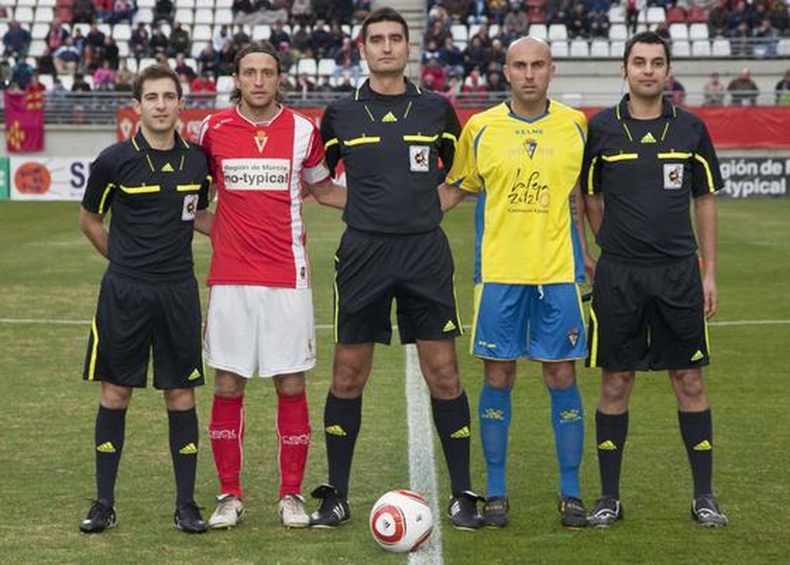 Los capitanes Óscar Sánchez y Raúl López flanquean al colegiado.   Foto: LOF