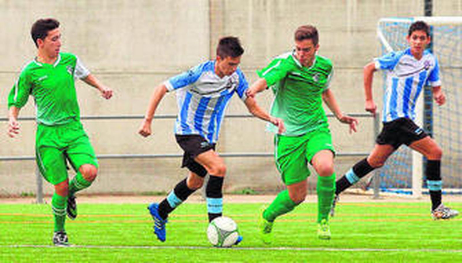 Un jugador del Don Bosco conduce el balón perseguido por un rival.
