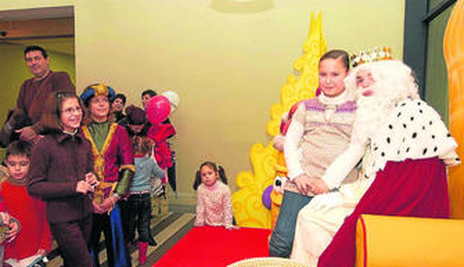 Una niña, con el rey Melchor en la planta baja de Diario de Sevilla, junto al buzón de las cartas.