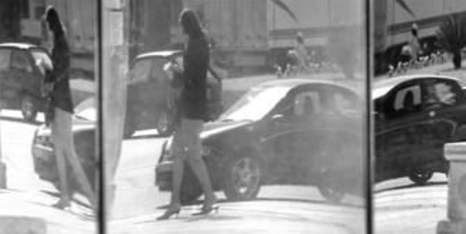 Un espejo devuelve la imagen distorsionada de una mujer trabajadora que repasa unos papeles en la calle. Un espejo devuelve la imagen distorsionada de una mujer trabajadora que repasa unos papeles en la calle.