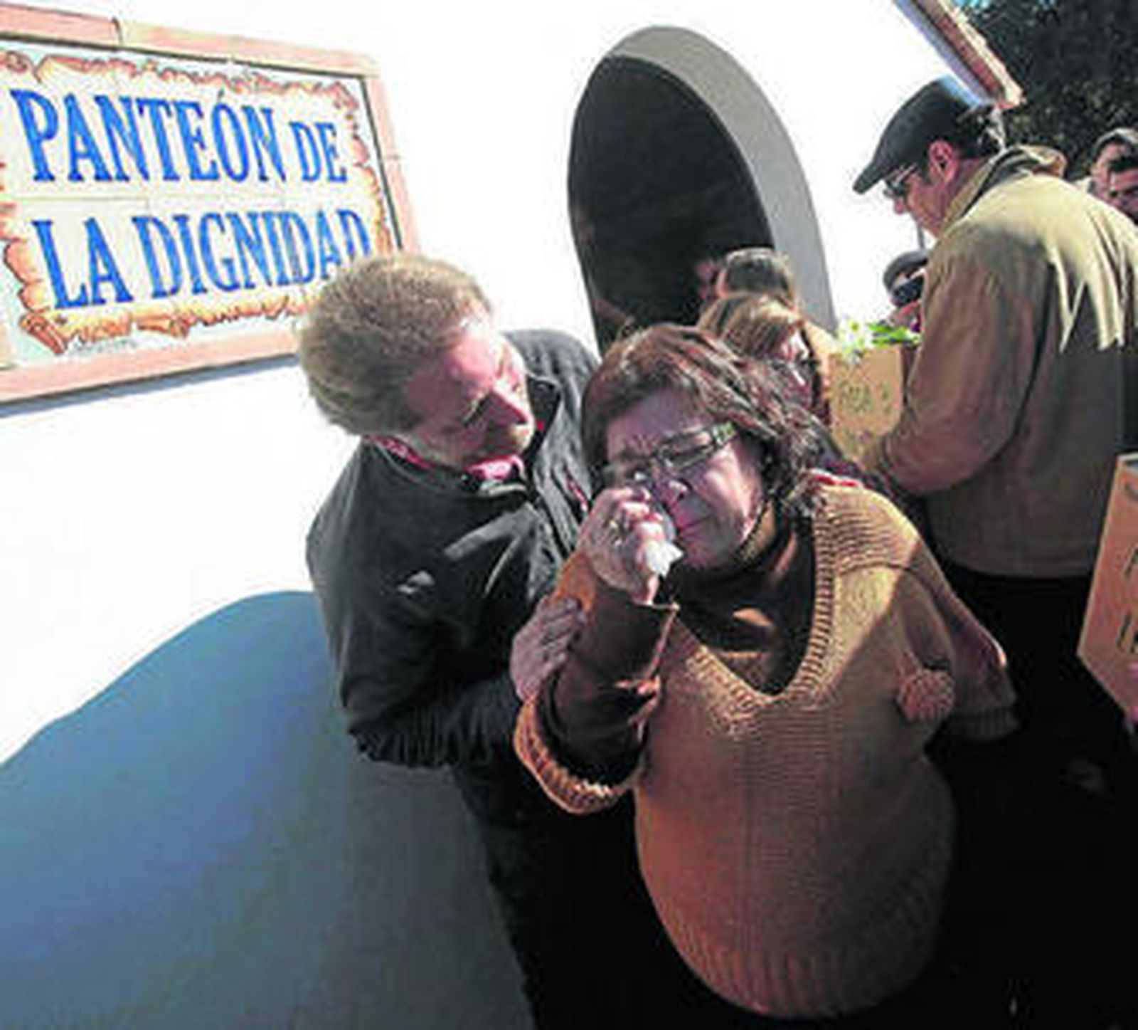 Una mujer llora tras dar sepultura a un familiar en La Sauceda.