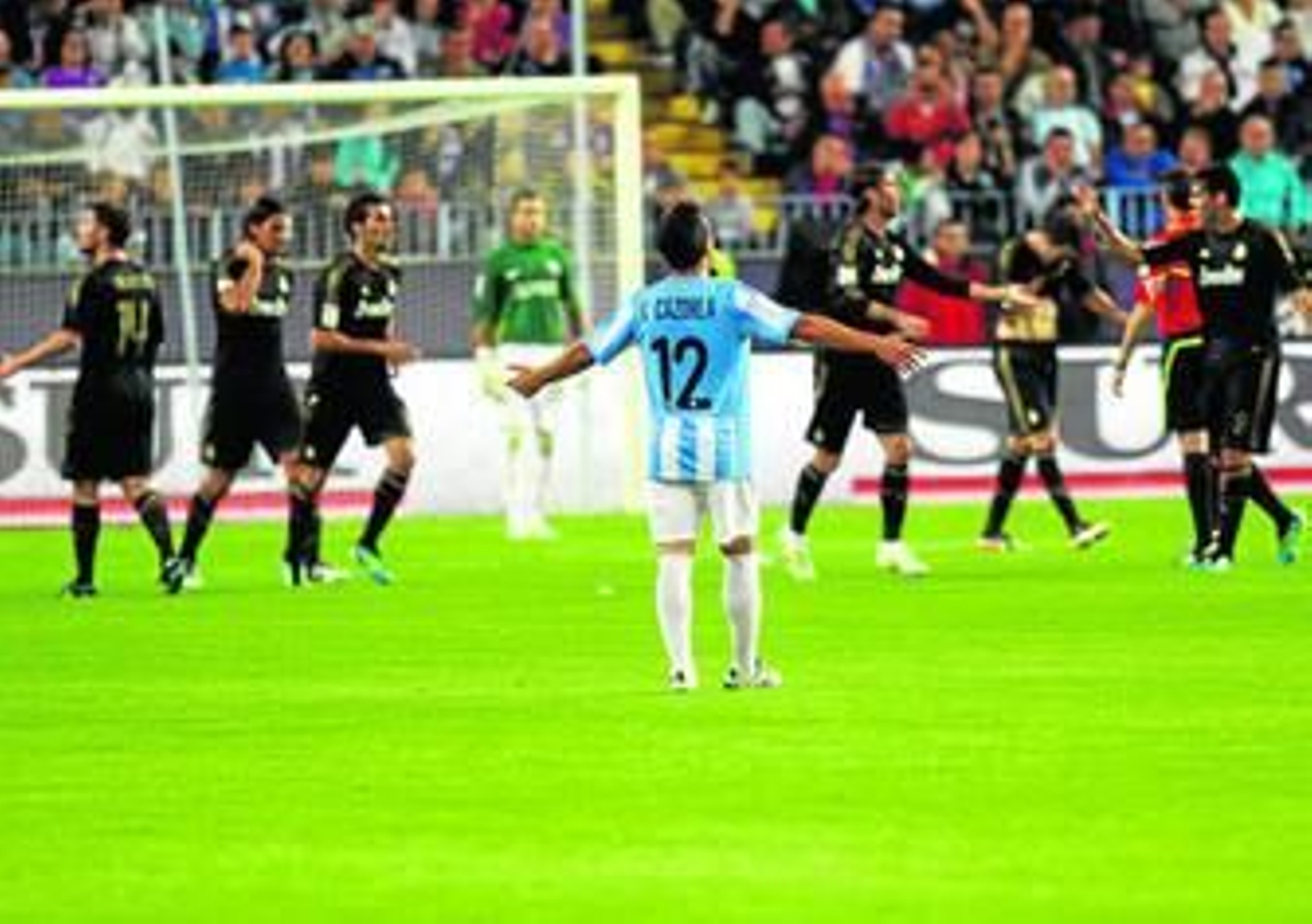 Cazorla gesticula con amargura mientras los jugadores del Madrid festejan uno de sus goles.