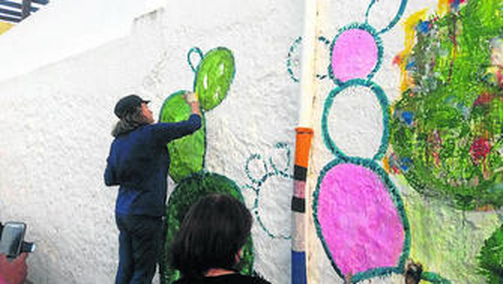 Una de las artistas plasma en las paredes de una de las casas del pueblo su obra dedicada a las chumberas.