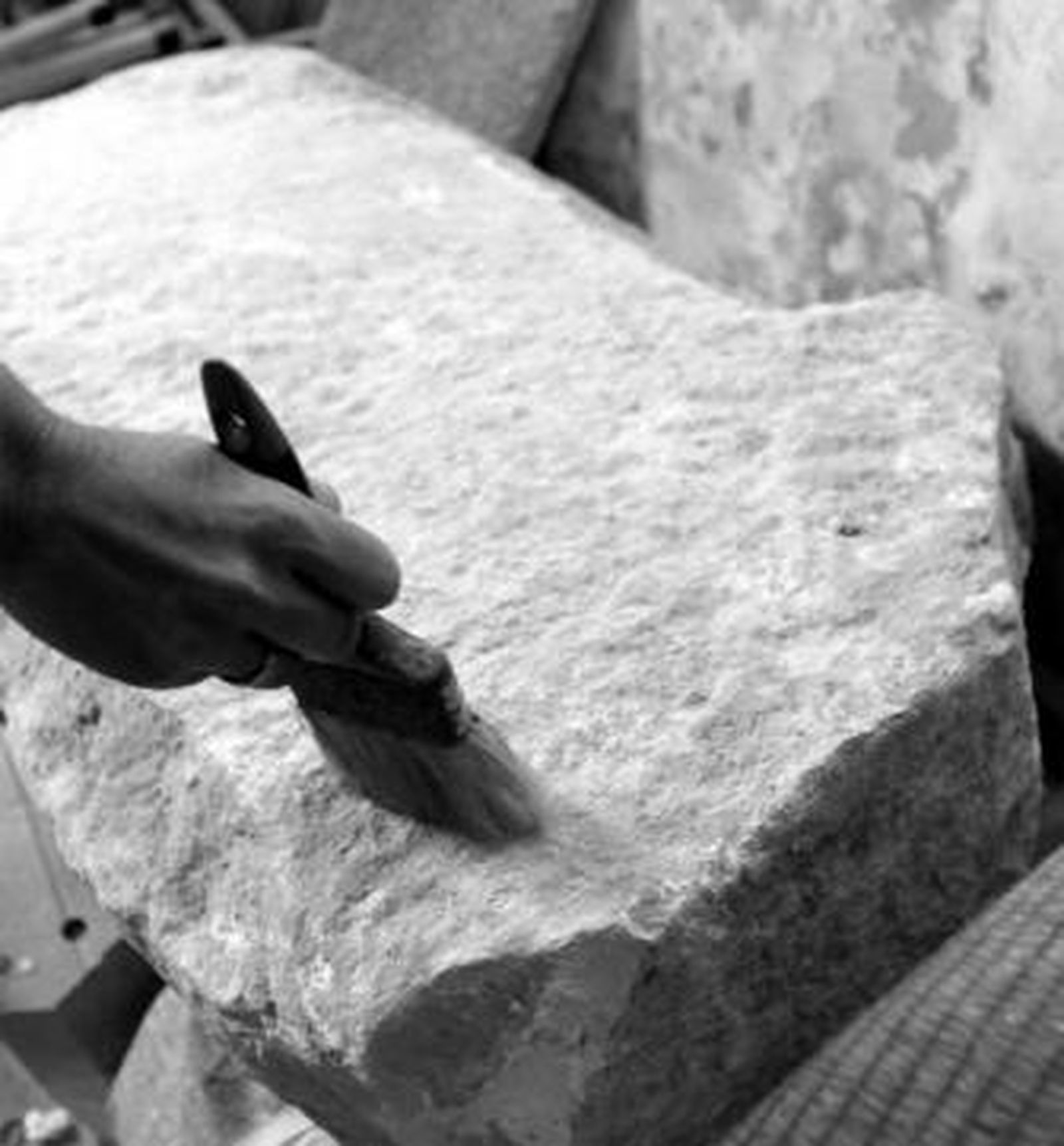 Uno de los arqueólogos examina un betilo o especie de monolito labrado.