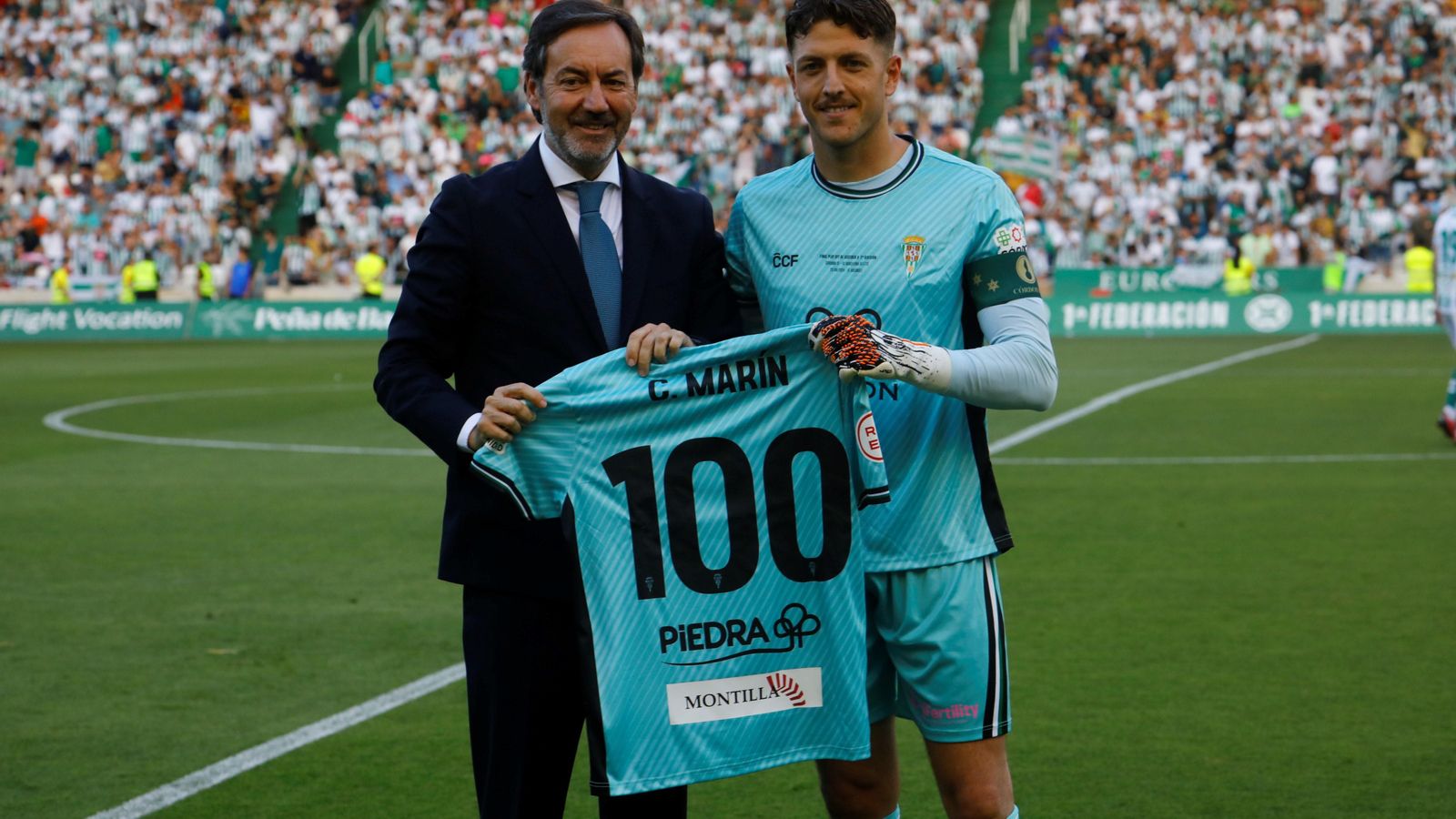 Carlos Marín recibe de manos una camiseta conmemorativa por alcanzar el centenar de partido con los blanquiverdes.