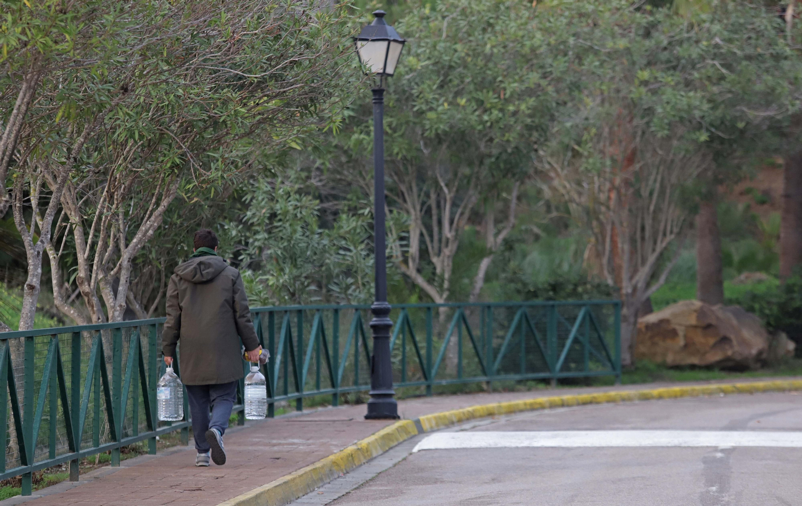 Un vecino de La Alcaidesa compra garrafas de agua tras declarar la Junta no apta para el consumo humano el agua corriente.