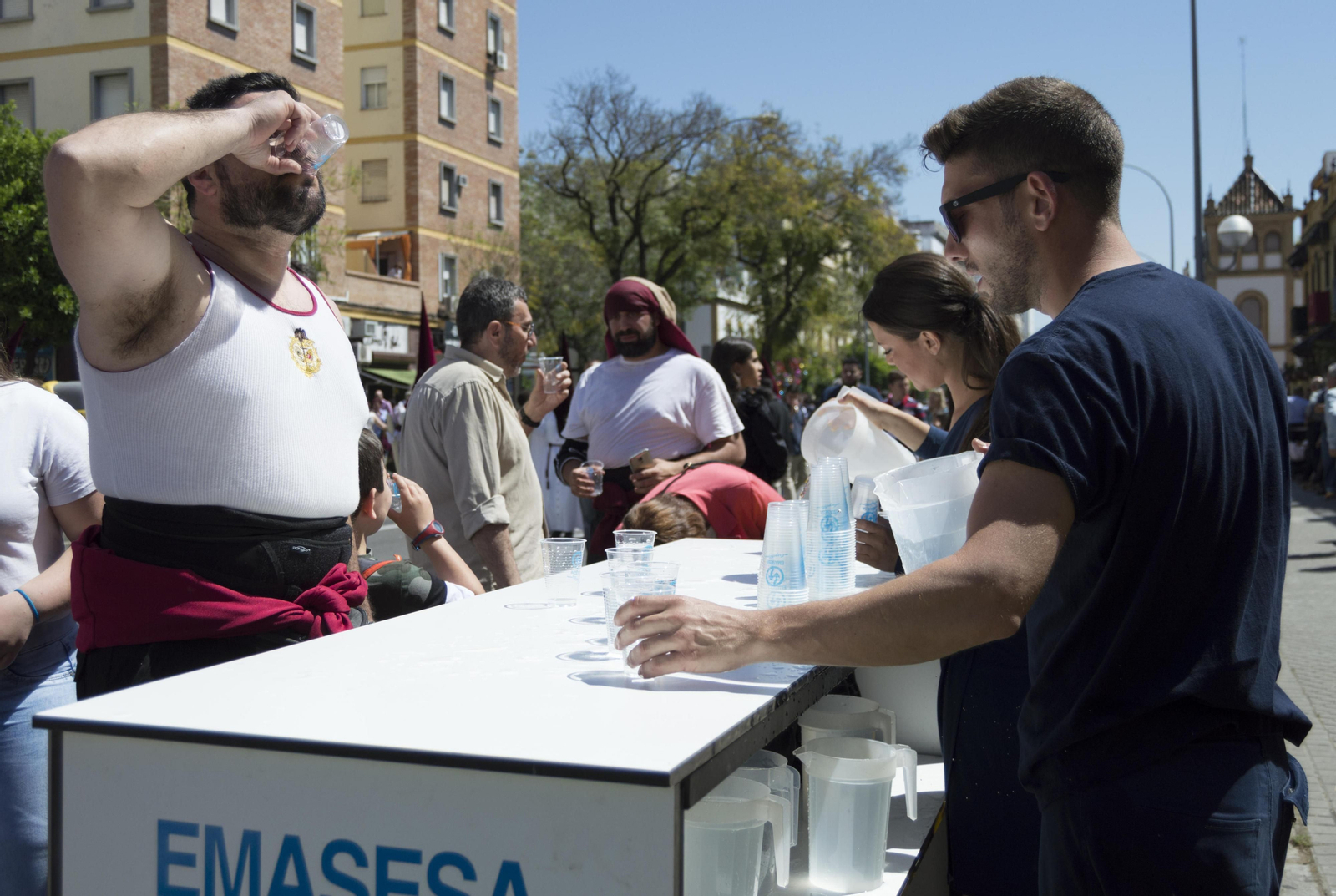 Costaleros del Cerro bebiendo agua en un puesto de Emasesa.