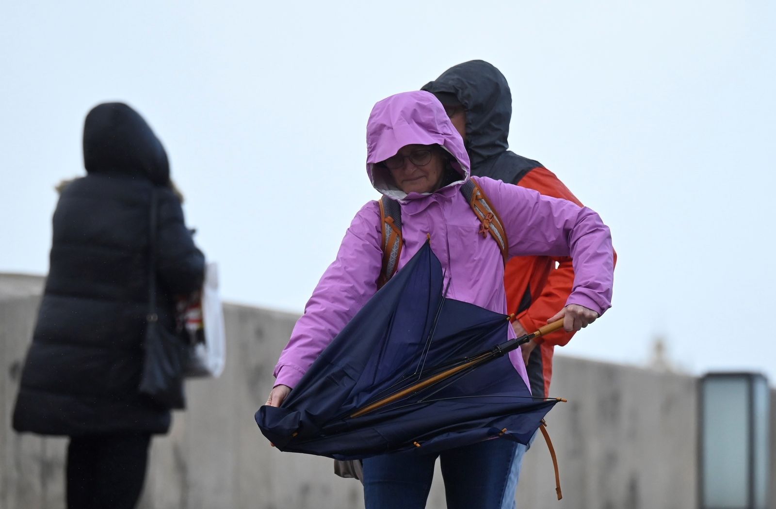 Una persona intenta abrir su paraguas en Córdoba para protegerse de la lluvia.