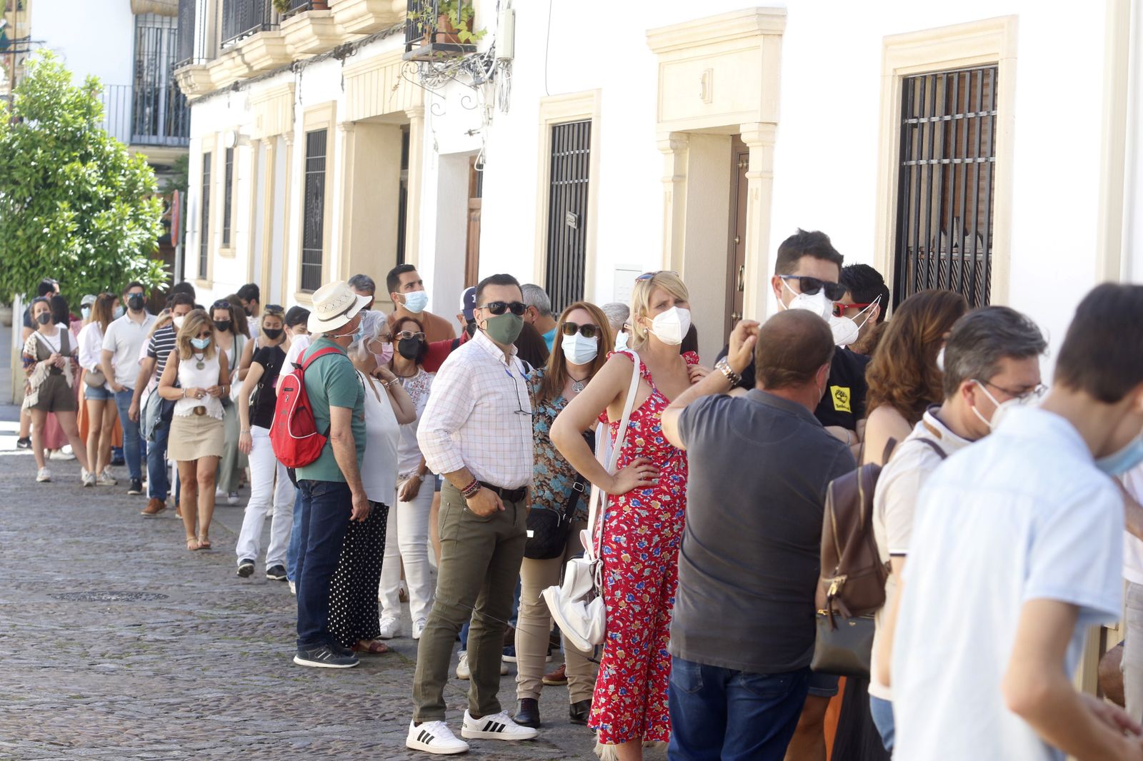 Multitud de personas hacen fila para entrar en un Patio.