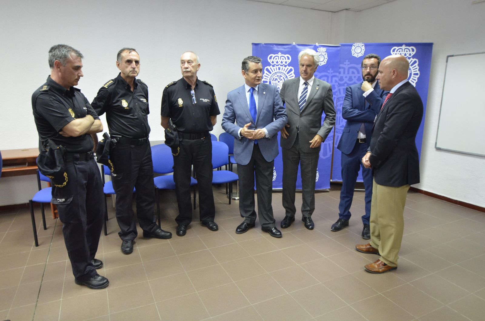 Tres agentes de la Policía Nacional conversan con Antonio Sanz, Agustín Muñoz, Juan Franco e Ignacio Macías, ayer en La Línea.