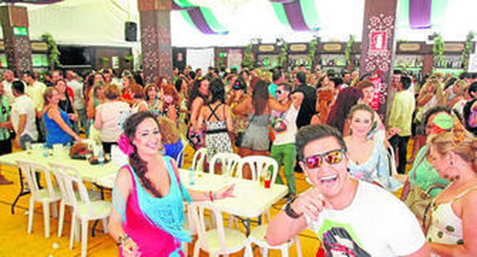 Imagen de una gran multitud de personas festejando con música en el interior de una caseta.