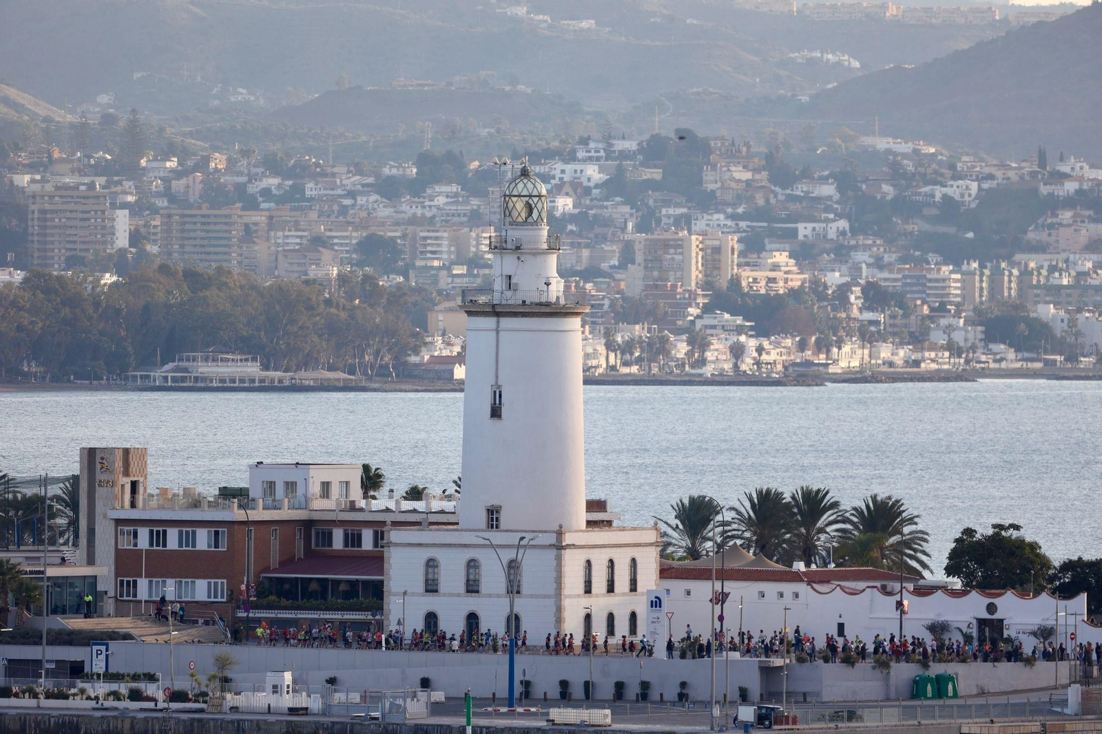 Los corredores pasan por delante de La Farola.