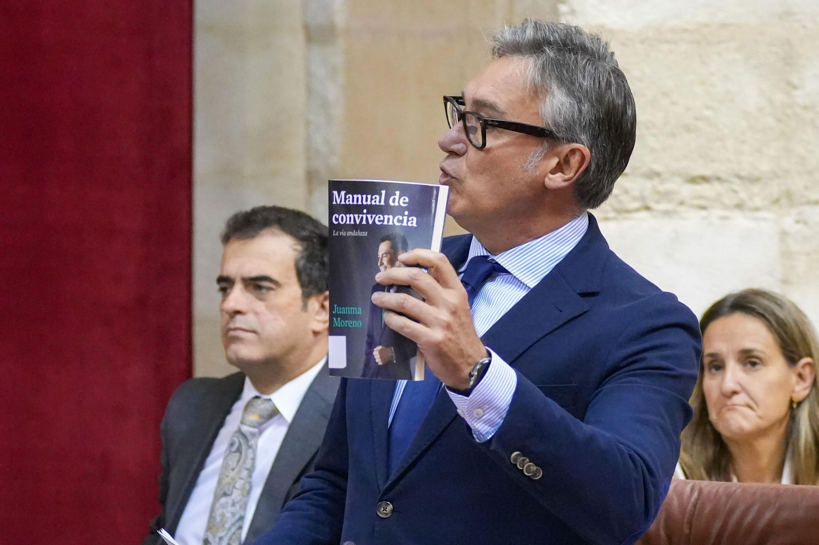 El portavoz de Vox, Manuel Gavira, con un ejemplar del libro de Juan Manuel Moreno.