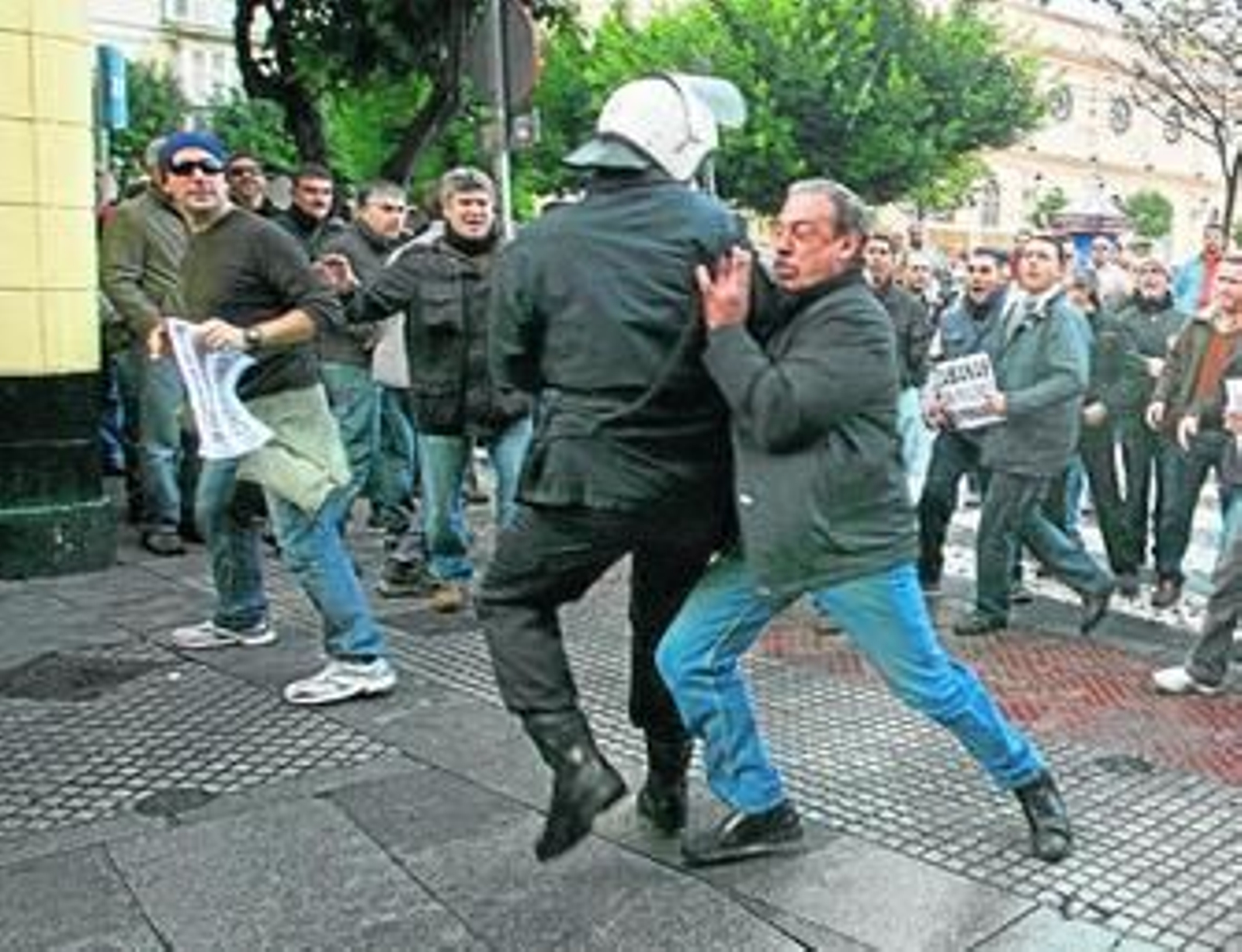 Uno de los manifestantes empuja a un policía ayer en la protesta de ex empleados de Delphi en Cádiz.