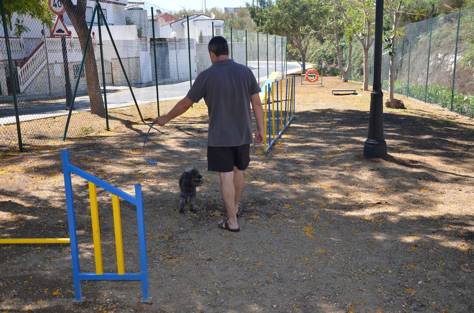 Un vecino con su perro en el parque canino de Fuengirola.