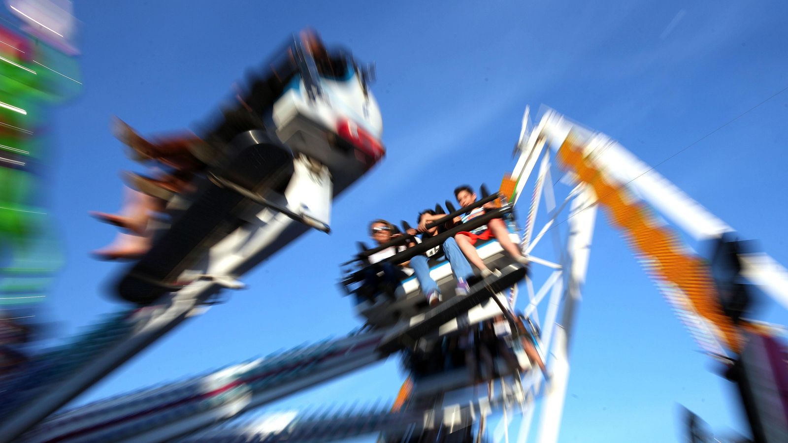 Tres adolescentes a bordo de una atracción de feria, en Los Barrios.