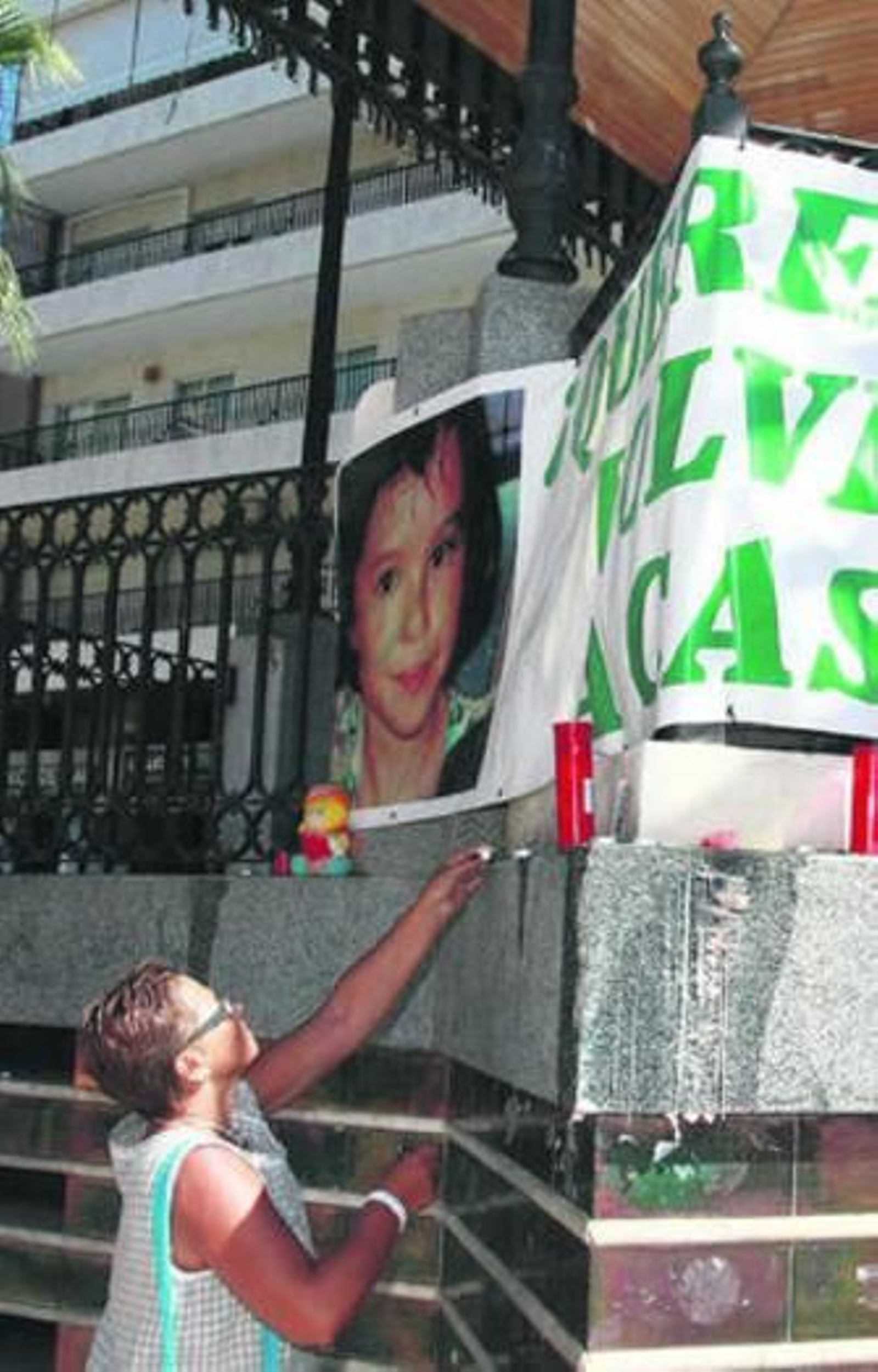 Una mujer deposita una vela en la plaza de las Monjas.