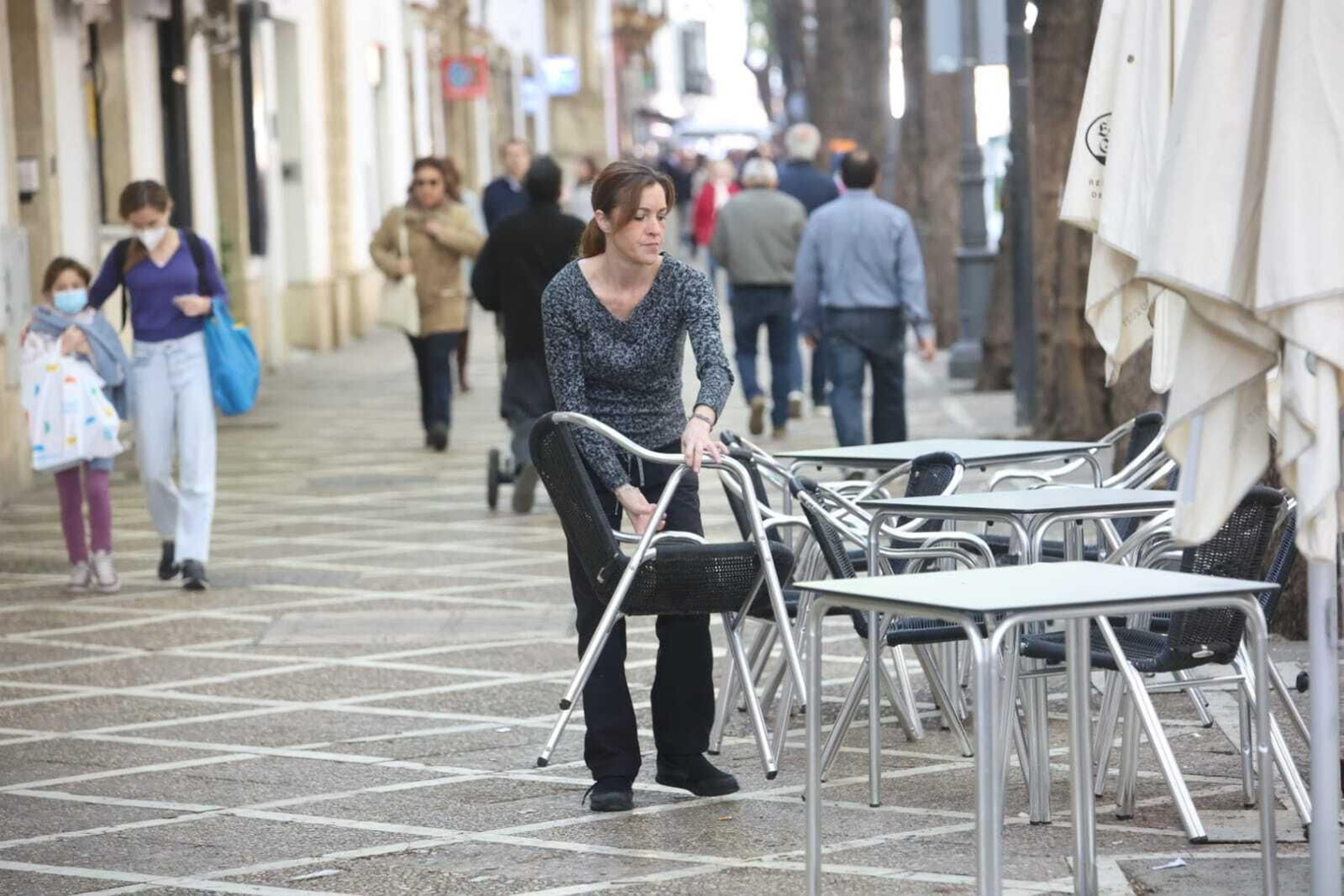 Una camarera monta la terraza de un bar en el centro de Jerez.