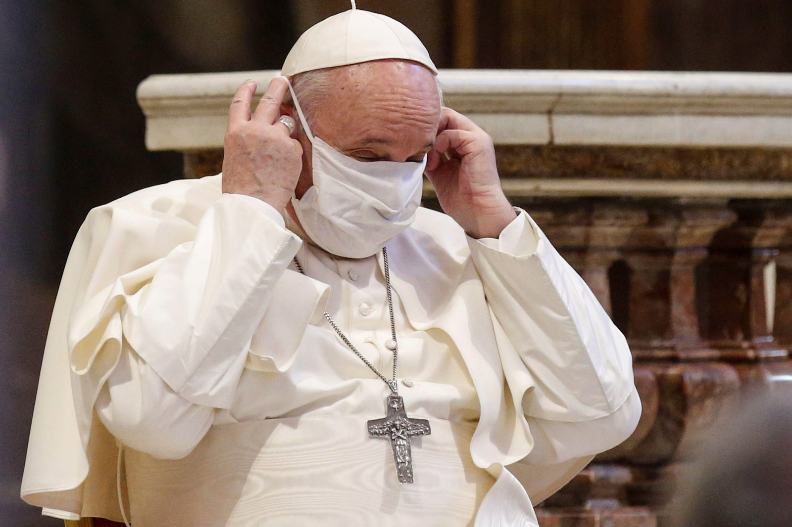El papa Francisco se coloca una mascarilla durante un acto de oración