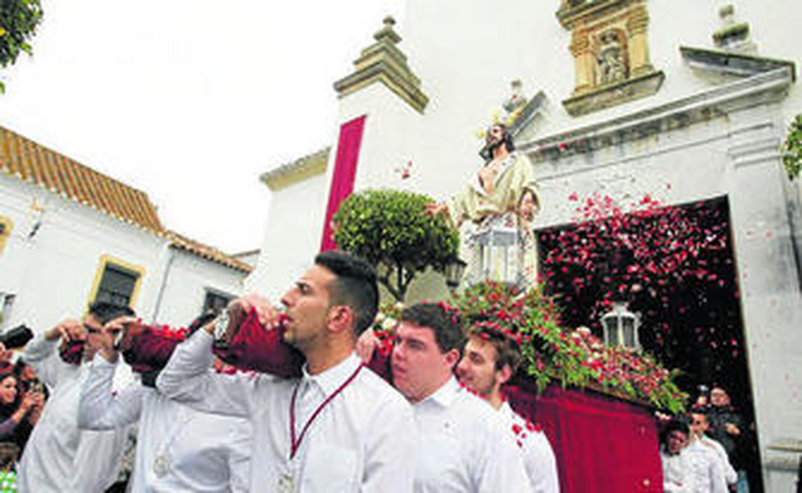 Pétalos para el Resucitado en su breve salida en San Roque.