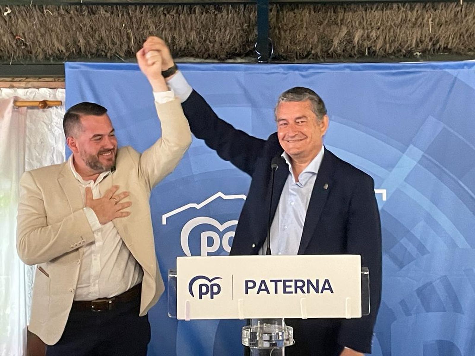 Antonio Sanz alza el brazo del candidato del PP, Andrés Clavijo, en señal de victoria.