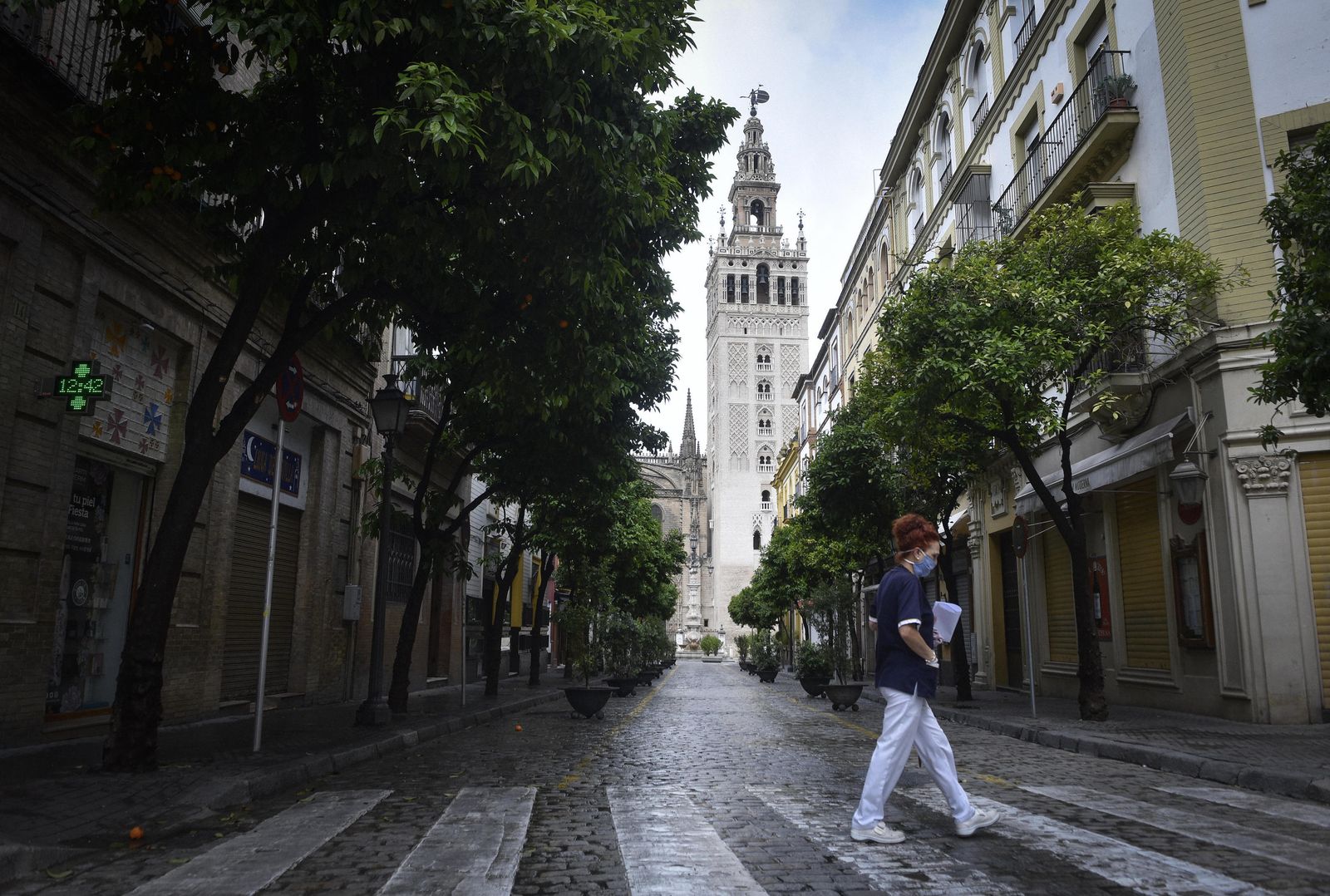 Una mujer con mascarilla cruza la calle Mateos Gago.