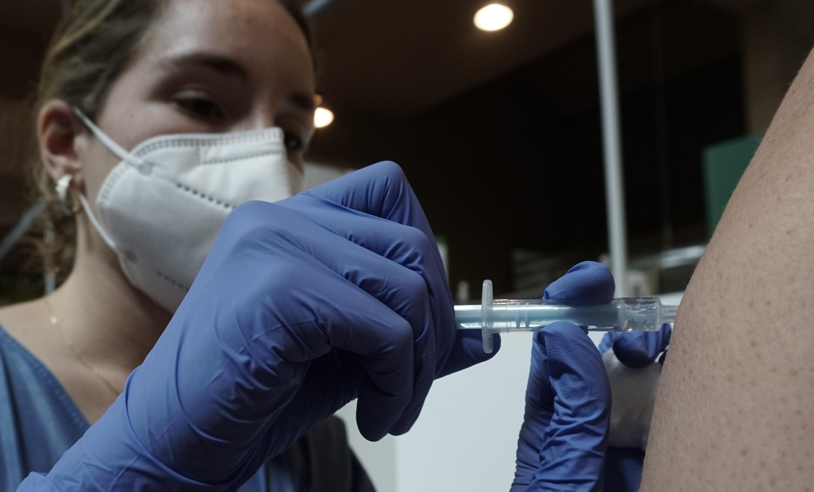 Detalle del momento en el que una enfermera inyecta la vacuna contra el coronavirus en el Estadio de la Cartuja.