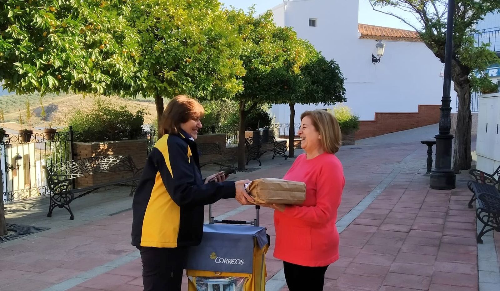 Una cartera de Correos entrega un paquete en un pueblo de Granada