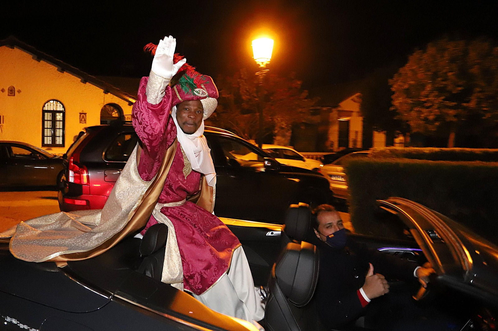 El rey Baltasar saluda a los vecinos del Barrio Obrero desde su descapotable.