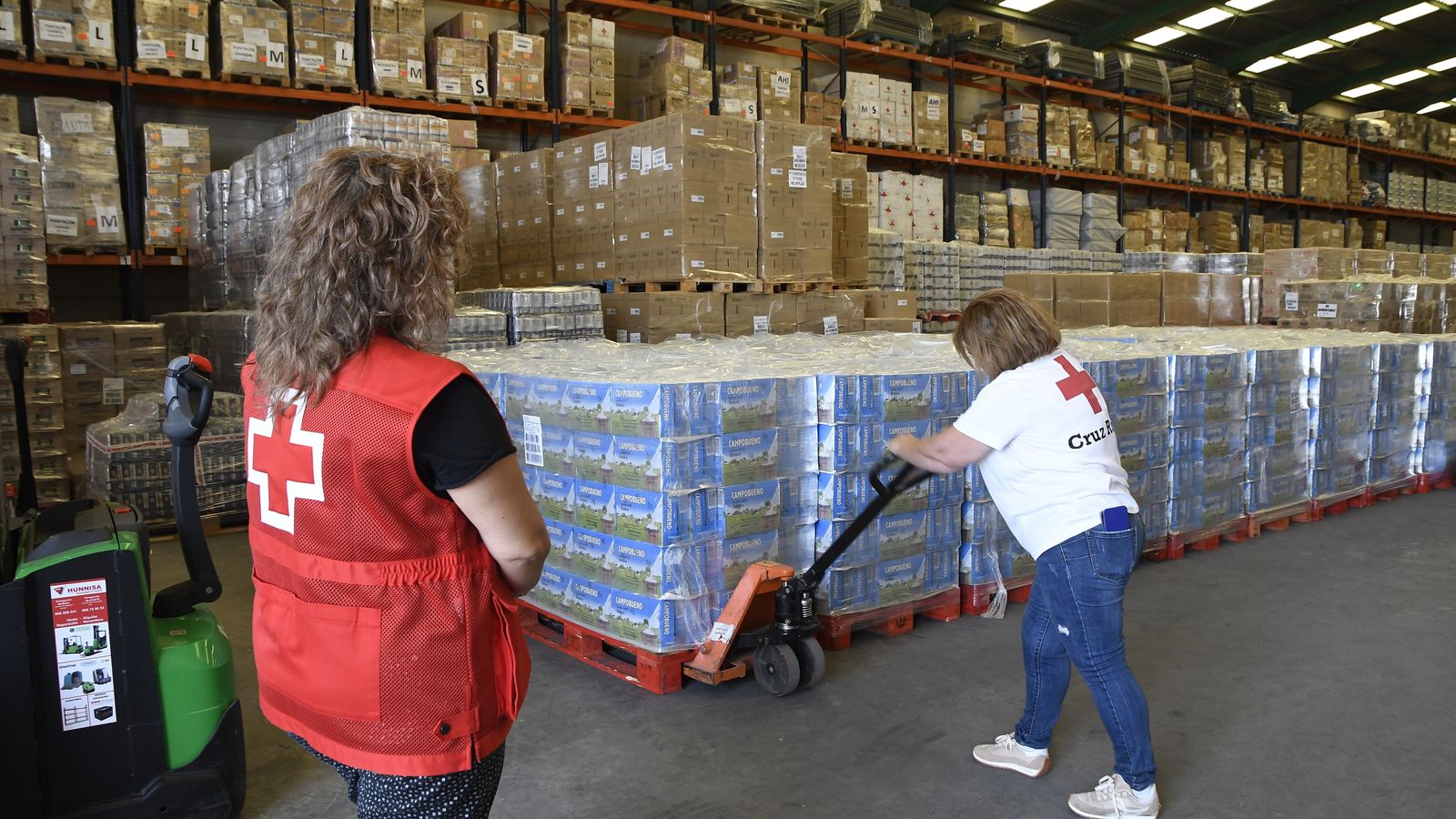 arias personas trabajan en el centro logistico de Cruz Roja en Almería que almacena 750.000 kilos de alimentos del Plan de Ayuda Alimentaria destinado a personas desfavorecidas.