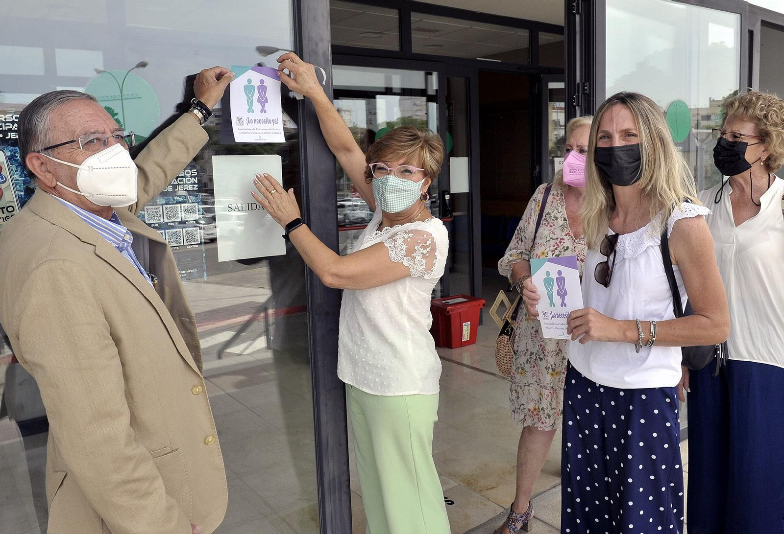 Fernando Criado y Carmen Collado, colocando el distintivo de la adhesión al proyecto en las instalaciones de la Delegación de Acción Social.