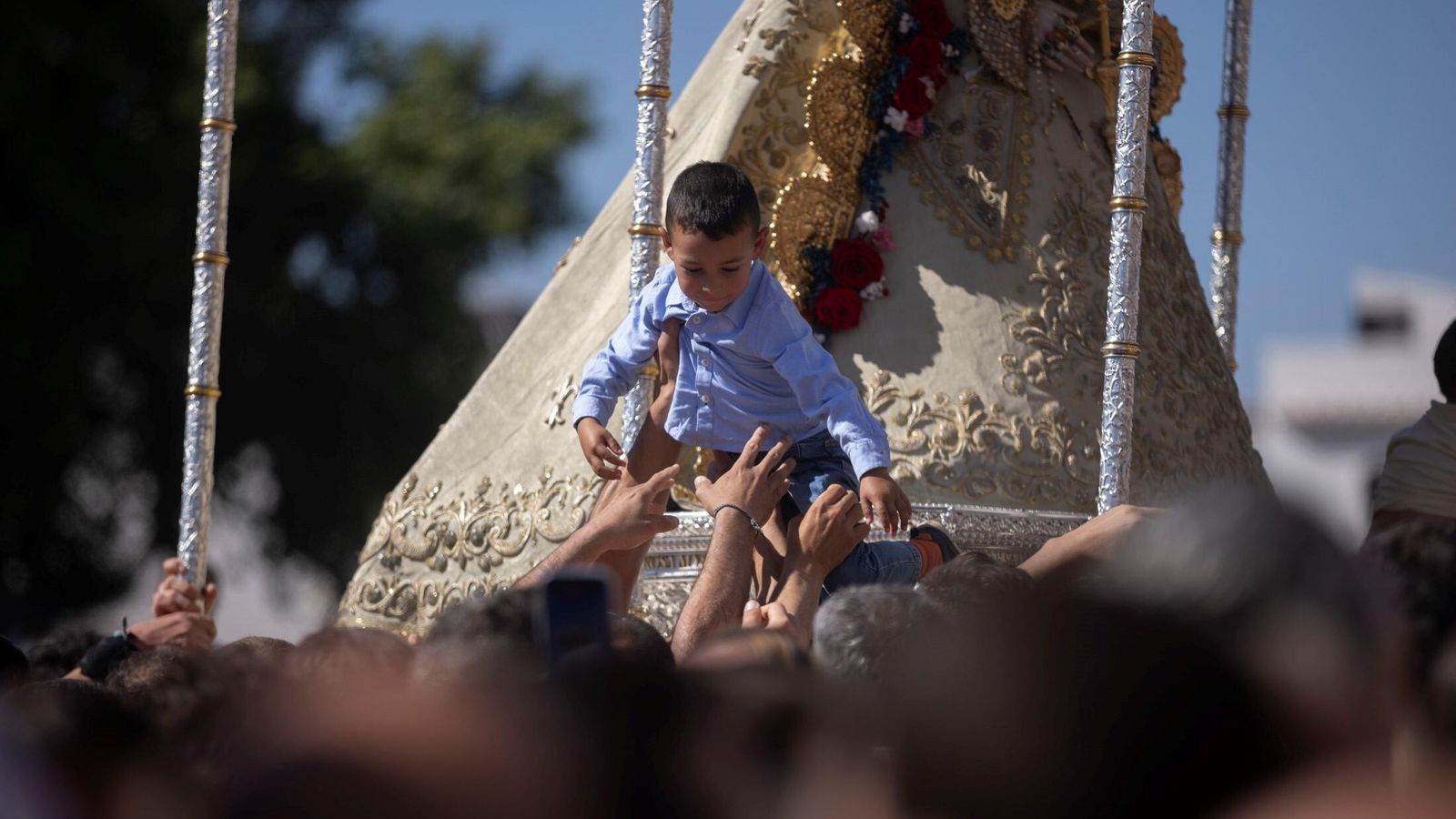 Suben a un niño junto a la Virgen durante la procesión de este 2024.