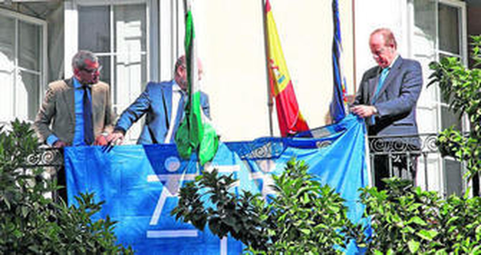 El decano del Colegio de Jerez, Marcos Camacho O'Neale, a la derecha, instala una pancarta en el balcón de la institución con motivo del día de la justicia gratuita.