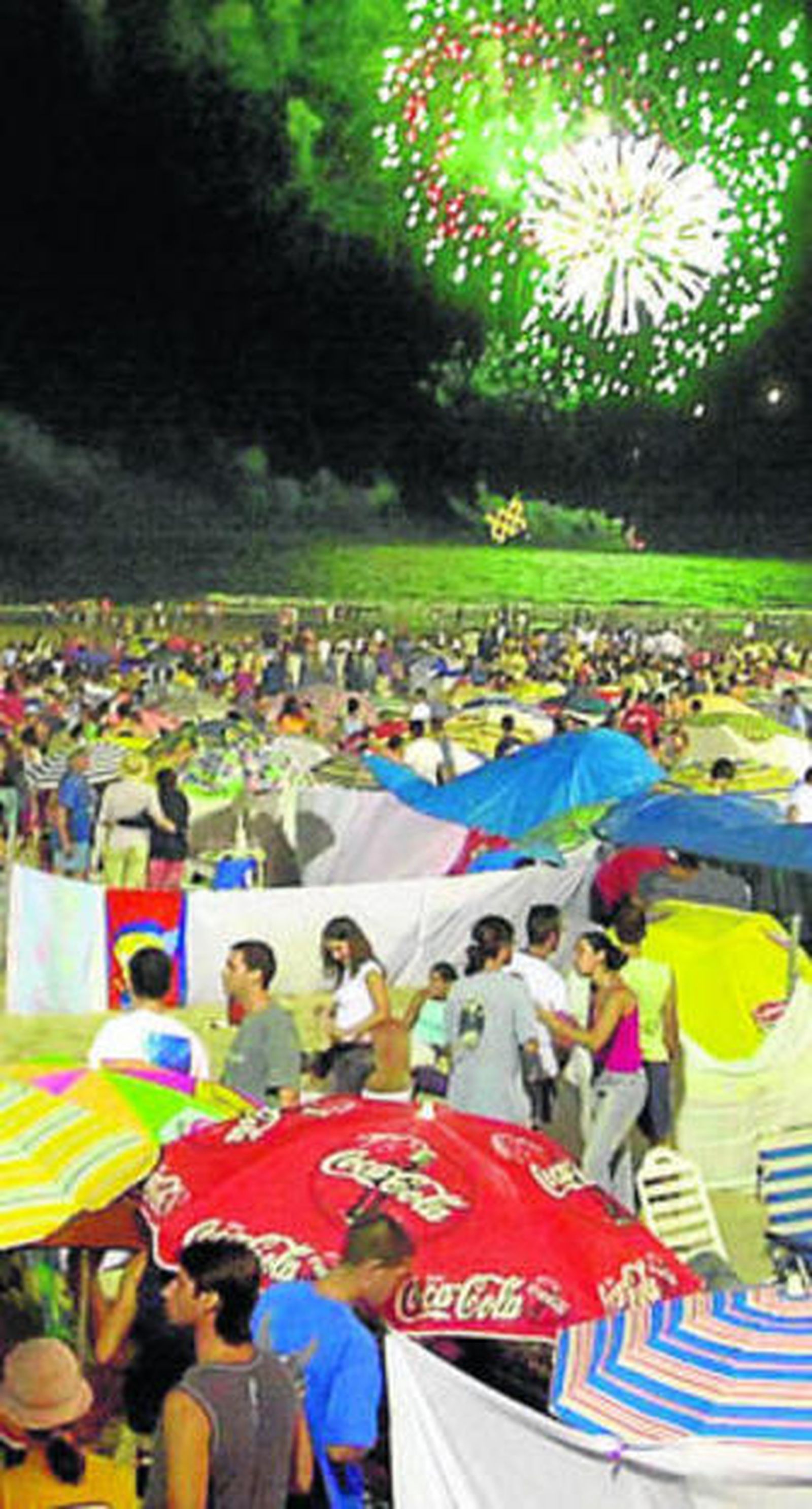 Las barbacoas con los fuegos artificiales al fondo.